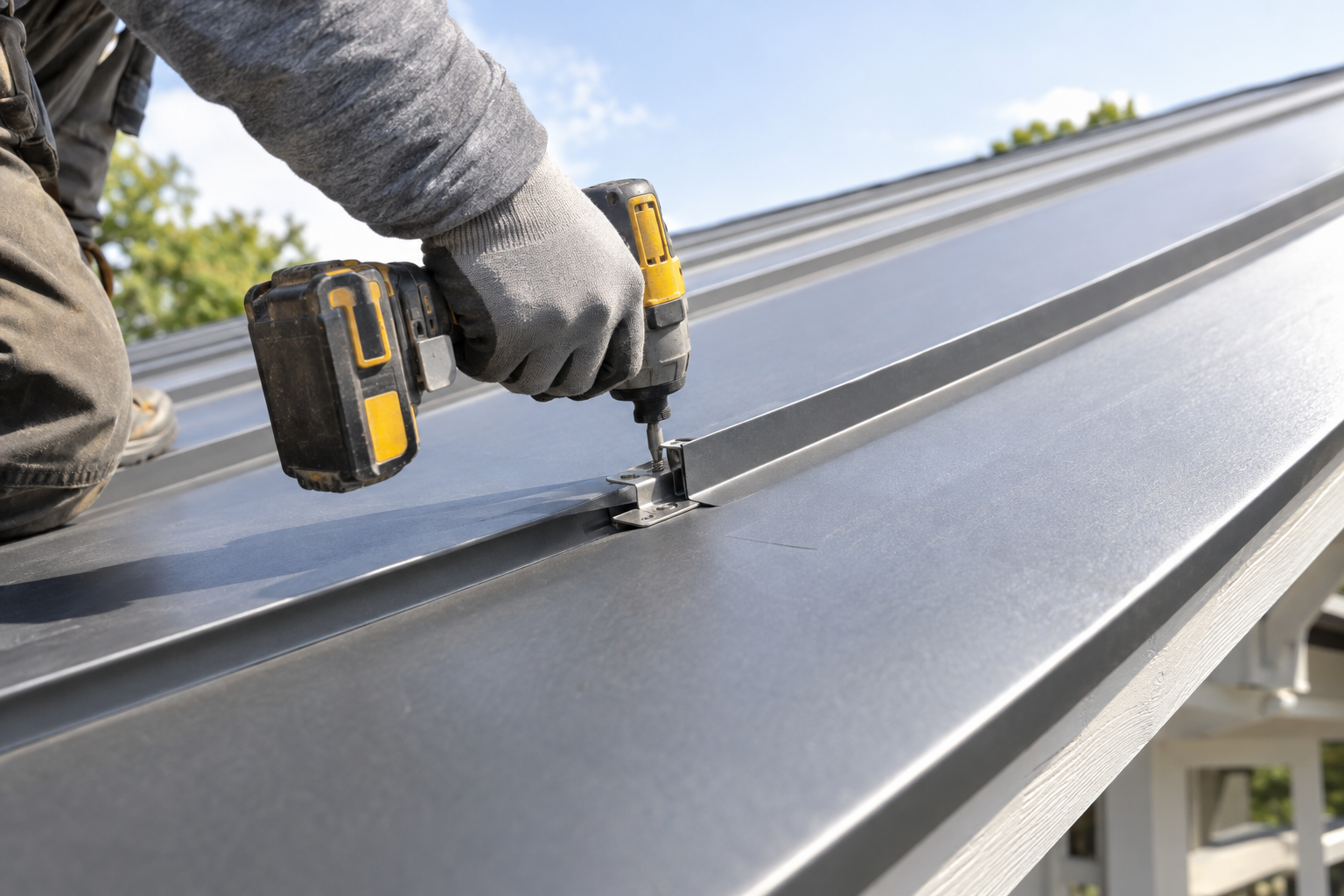 Standing-seam metal roof panels being fastened at a concealed clip